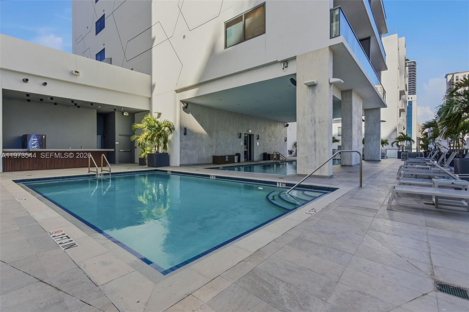 229 Southwest 9th Street, Unit 407 Miami, FL 33130 - Photo 1 of 29 a view of a swimming pool with chairs