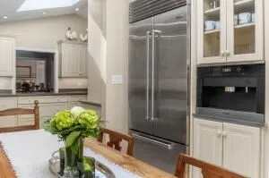 a close view of a faucet a sink and a refrigerator in a kitchen