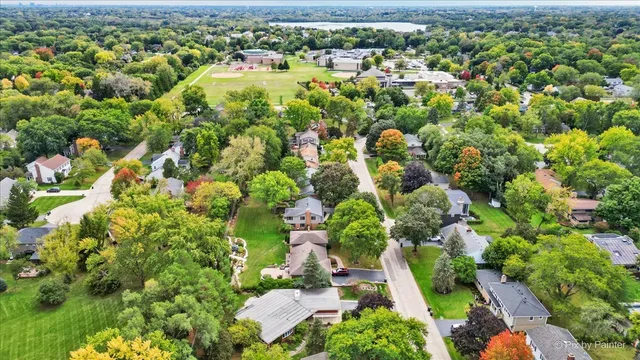 an aerial view of residential houses with outdoor space and trees