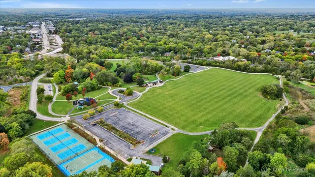 an aerial view of a residential houses with outdoor space and trees
