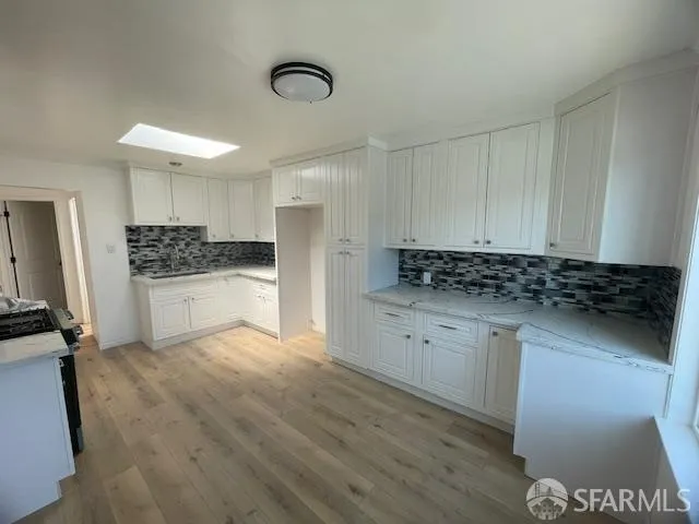 a kitchen with granite countertop a stove and cabinets