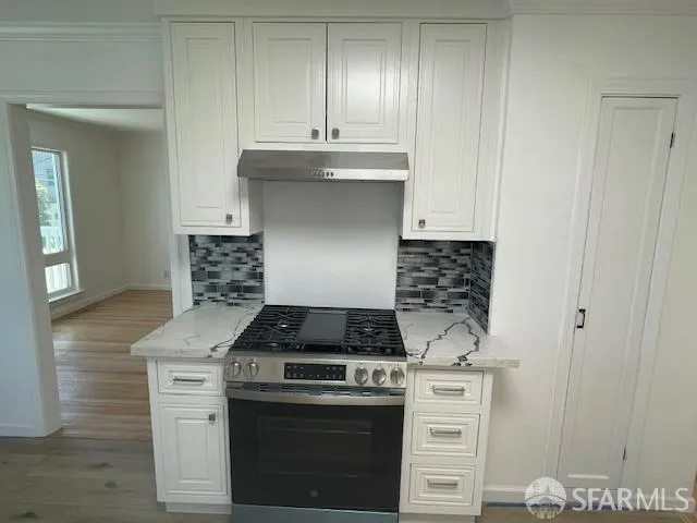 a kitchen with white cabinets and appliances
