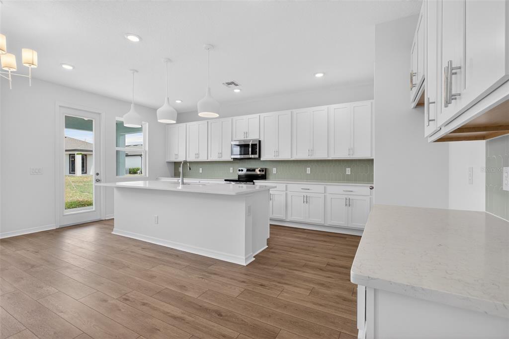 5765 Haystack Drive St. Cloud, FL 34771 - Photo 13 of 42 a kitchen with granite countertop white cabinets and white appliances