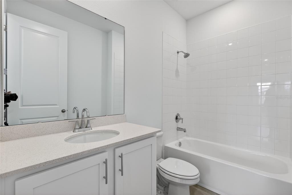 5765 Haystack Drive St. Cloud, FL 34771 - Photo 20 of 42 a bathroom with a granite countertop sink a toilet and a bathtub
