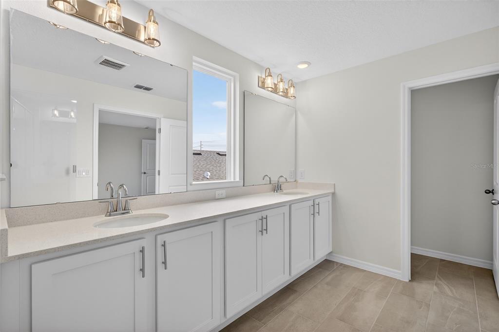 5765 Haystack Drive St. Cloud, FL 34771 - Photo 34 of 42 a bathroom with a double vanity sink and a mirror