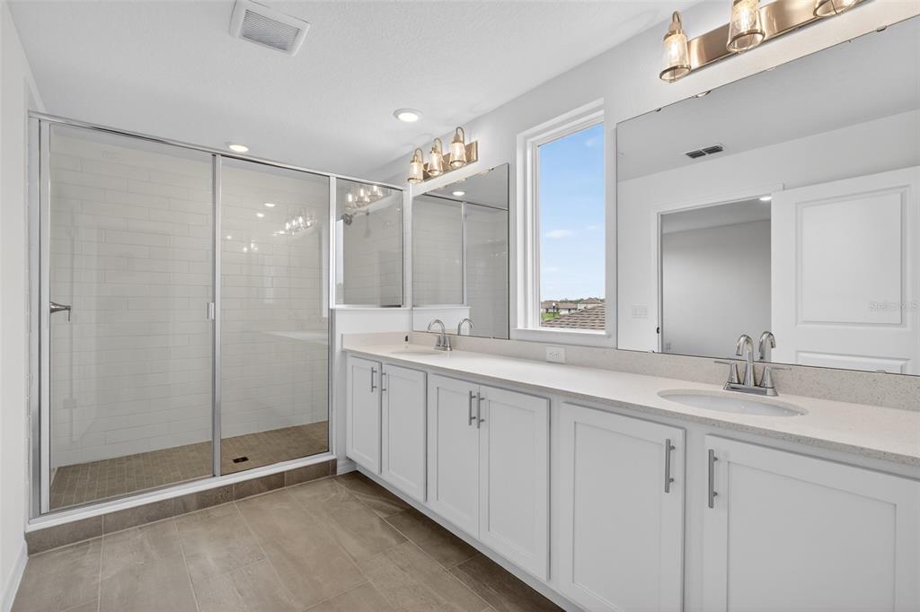 5765 Haystack Drive St. Cloud, FL 34771 - Photo 35 of 42 a bathroom with a shower sink and mirror