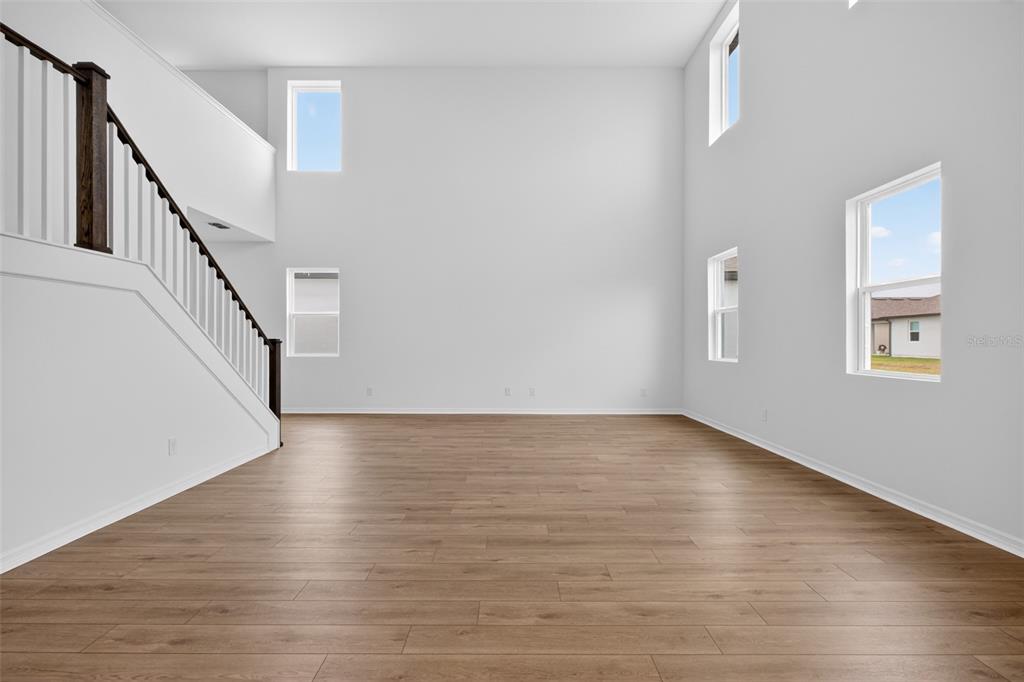 5765 Haystack Drive St. Cloud, FL 34771 - Photo 8 of 42 a view of an empty room with wooden floor and stairs