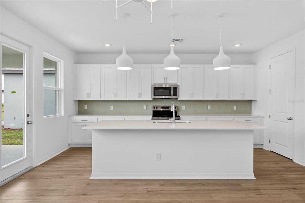 5765 Haystack Drive St. Cloud, FL 34771 - Photo 10 of 42 a kitchen with stainless steel appliances granite countertop a sink a stove and a refrigerator