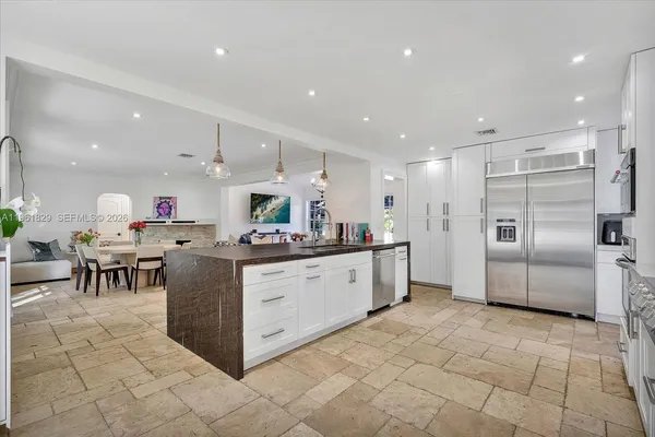 a kitchen with stainless steel appliances kitchen island granite countertop a table and chairs in it
