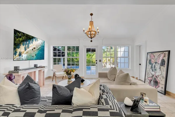 a living room with furniture a flat screen tv and a large window