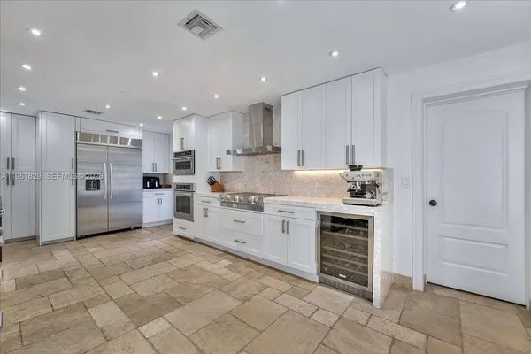 a kitchen with stainless steel appliances granite countertop a refrigerator and a sink