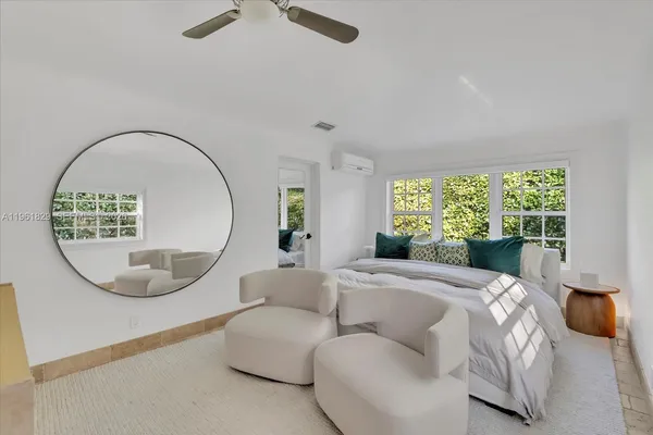 a bed room with a bed a mirror and a large window