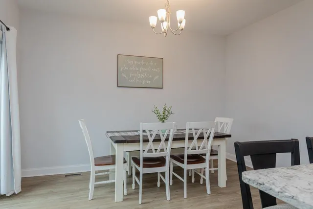 a dining room with furniture a chandelier and a rug
