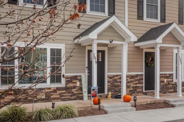 a front view of a house with large trees
