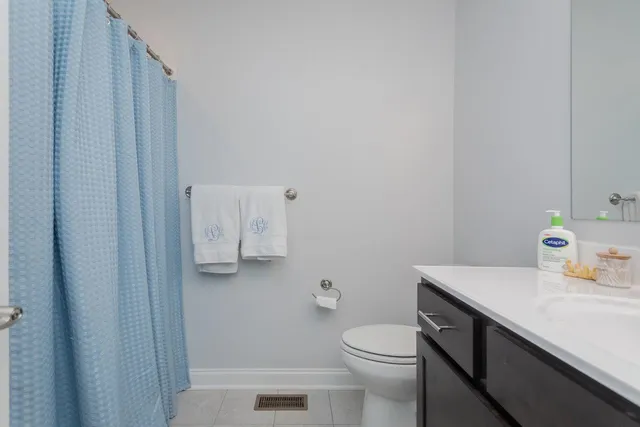 a bathroom with a sink a toilet and a shower curtain