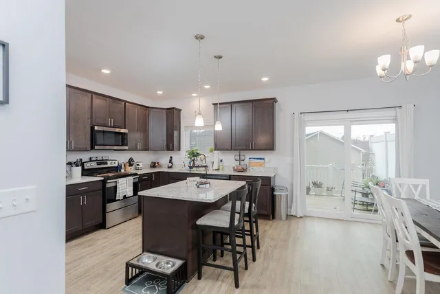 a large kitchen with cabinets table and chairs