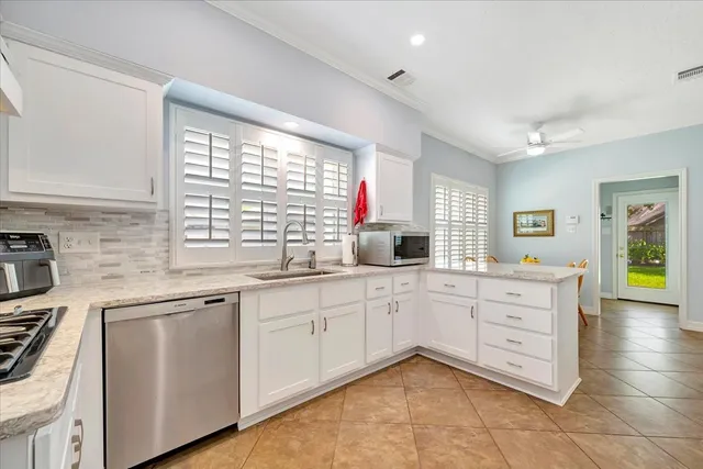a kitchen with white cabinets and sink