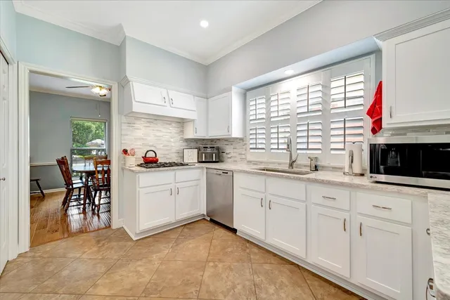 a kitchen with granite countertop white cabinets and white appliances