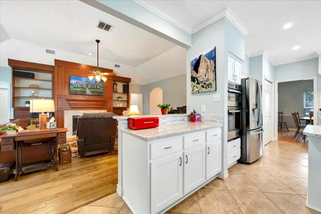 a view of a kitchen with fridge and a view of living room