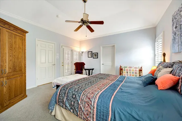 a bedroom with a large bed and ceiling fan