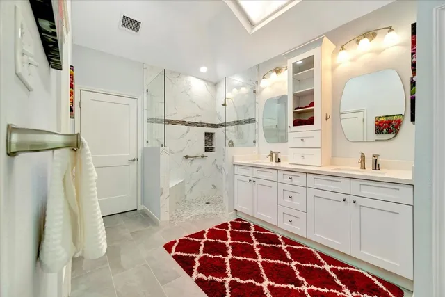 a spacious bathroom with a double vanity sink mirror and shower