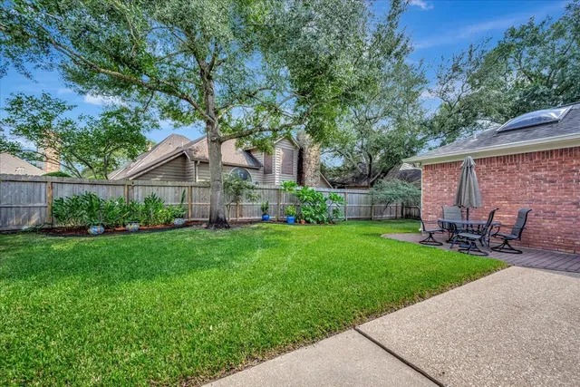 a backyard of a house with table and chairs