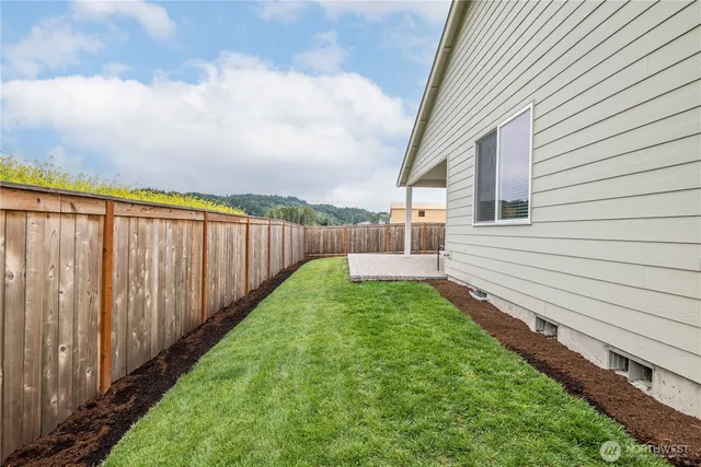 a view of a backyard with wooden fence