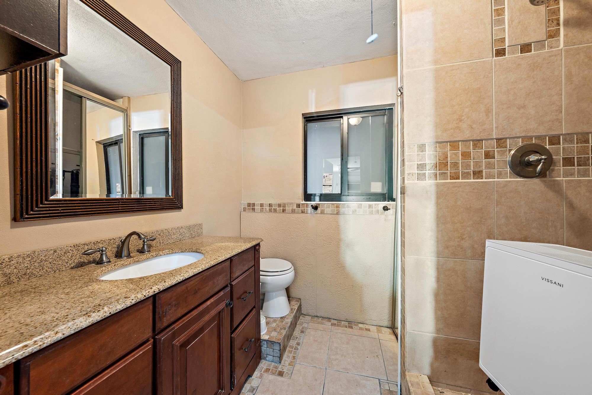 1120 Singer Drive Riviera Beach, FL 33404 - Photo 12 of 37 a bathroom with a granite countertop sink and a mirror