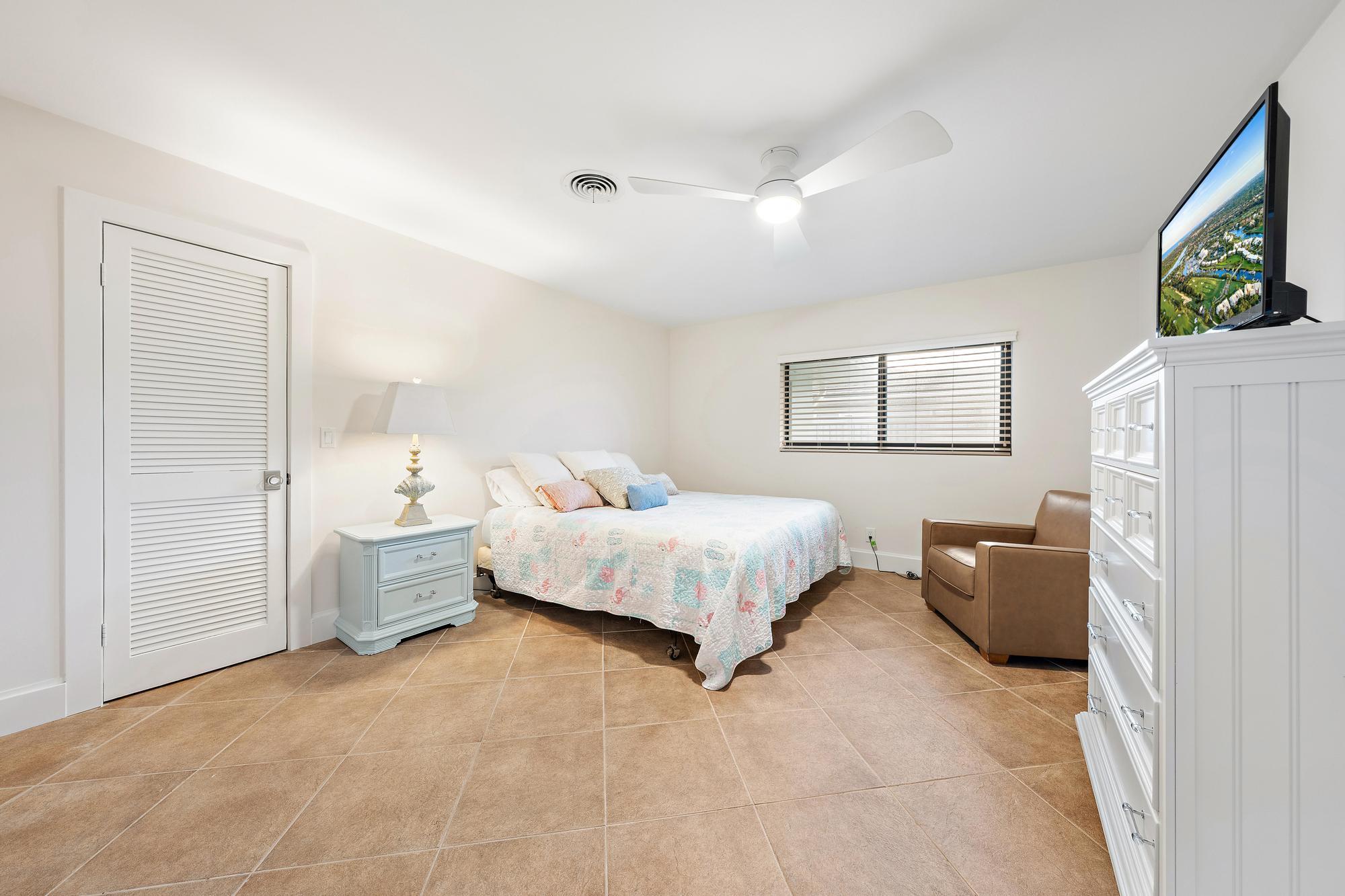 1120 Singer Drive Riviera Beach, FL 33404 - Photo 16 of 37 a spacious bedroom with a bed and a couch