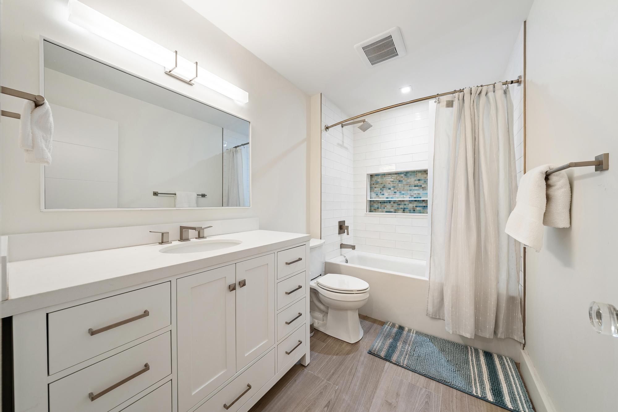 1120 Singer Drive Riviera Beach, FL 33404 - Photo 17 of 37 a bathroom with a granite countertop sink toilet a mirror a vanity and shower