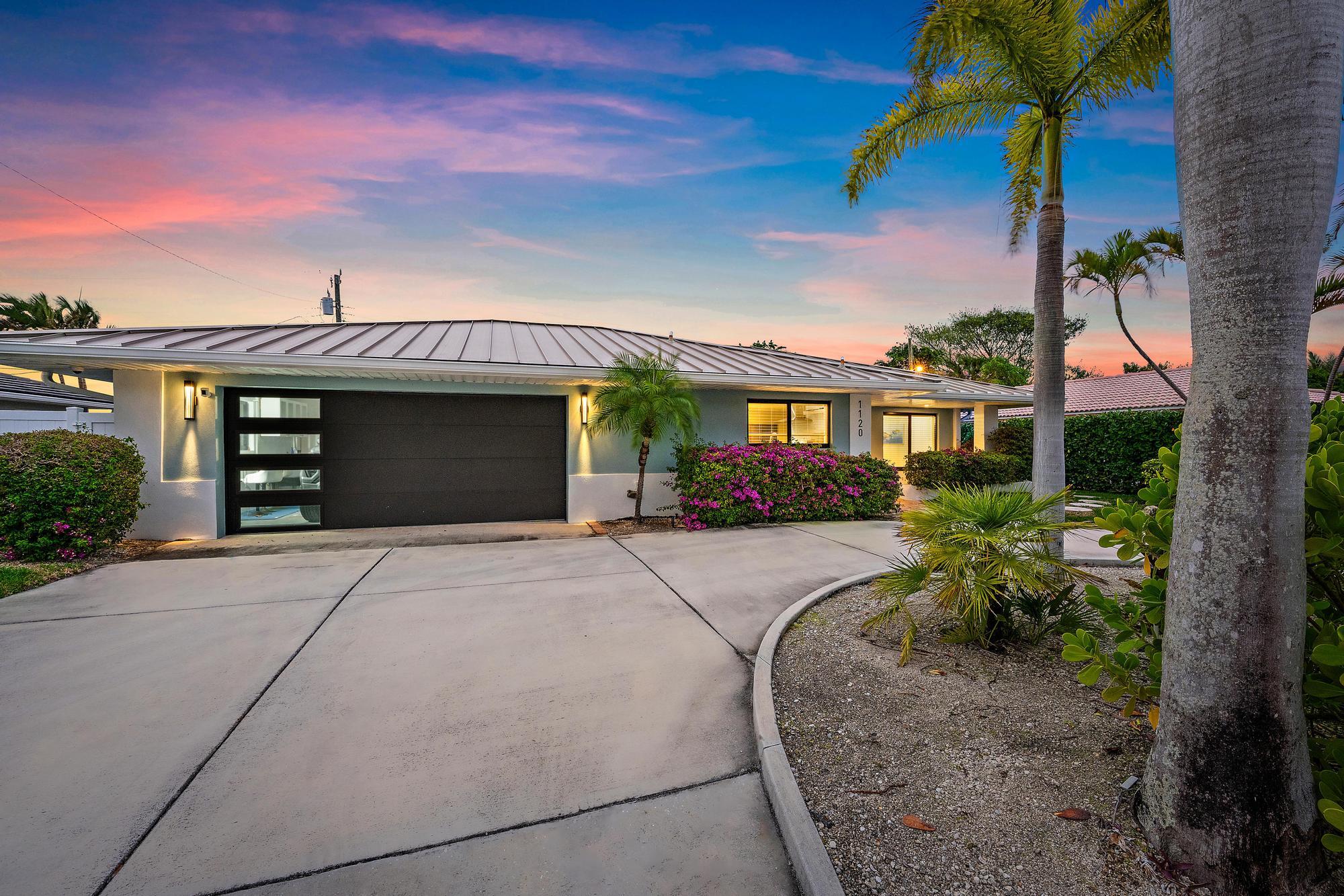 1120 Singer Drive Riviera Beach, FL 33404 - Photo 19 of 37 a front view of a house with a garden