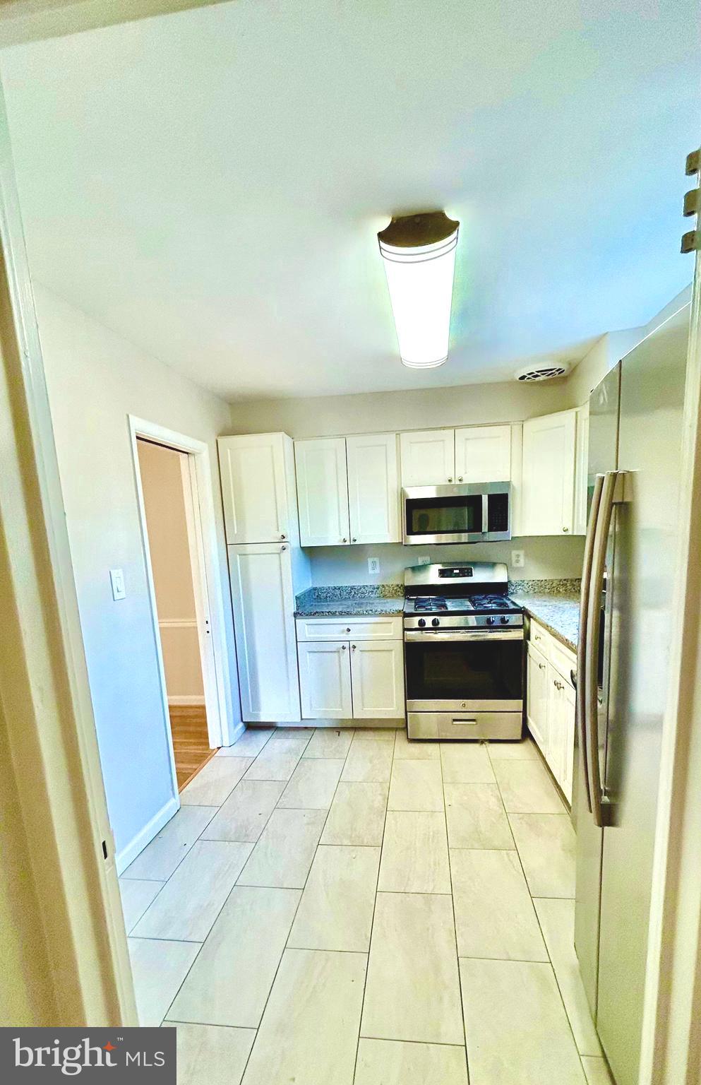 5319 Pooks Hill Road, Unit 1 Bethesda, MD 20814 - Photo 11 of 37 a kitchen with stainless steel appliances a stove a sink and a refrigerator