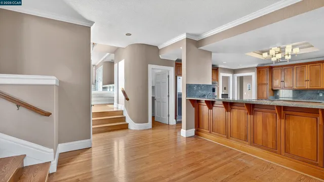 a view of a large kitchen with an entryway and wooden floor