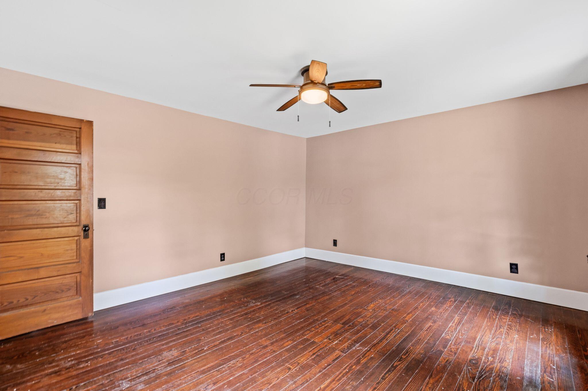 107 Price Road Columbus, OH 43230 - Photo 31 of 51 Expansive room featuring wood-finish flooring, a ceiling fan with integrated lighting, a paneled wood door, and baseboard trim