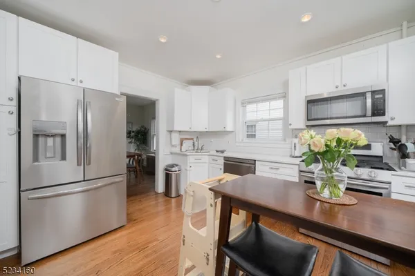 a kitchen with refrigerator cabinets and wooden floor