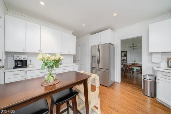 a kitchen with a refrigerator and a wooden floor
