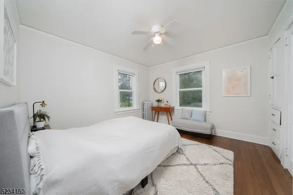 a bedroom with a bed wooden floor and window