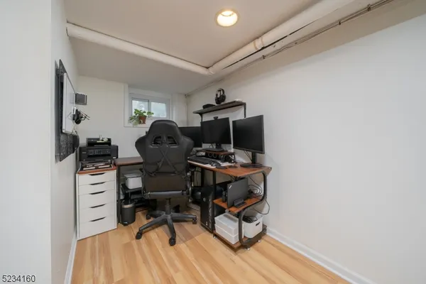 a view of a workspace with furniture and a window