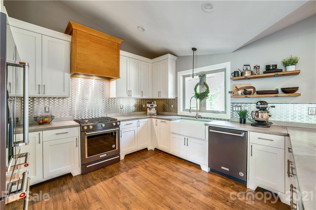 5016 Kiser Island Road Terrell, NC 28682 - Photo 16 of 37 a kitchen with stainless steel appliances granite countertop a stove a sink and white cabinets with wooden floor