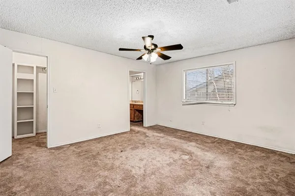 a view of an empty room with a ceiling fan