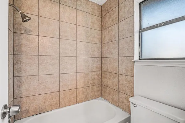 a bathroom with a toilet and a shower