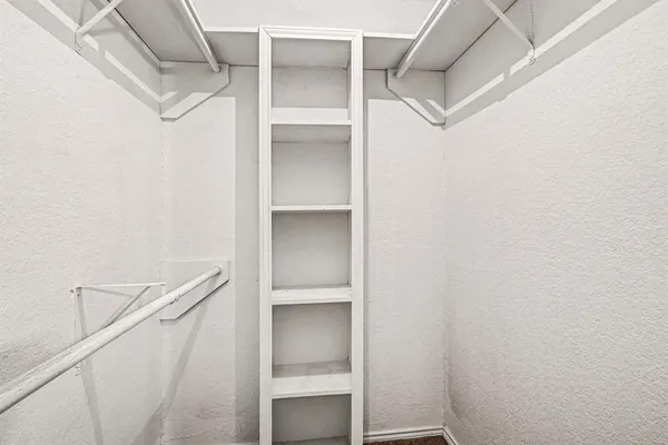 a view of walk in closet with empty racks