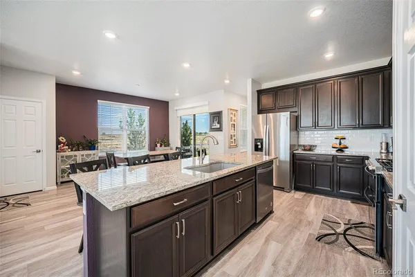 a kitchen with granite countertop a sink stove and refrigerator
