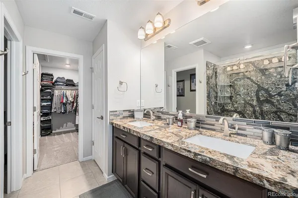 a bathroom with double vanity sinks a vanity and a shower