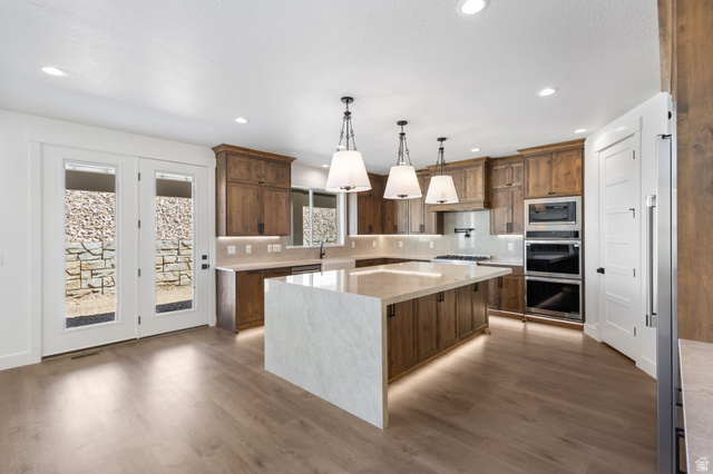 692 East Mountain Road North Ogden, UT 84414 - Photo 2 of 17 Spacious kitchen featuring an oversized island with waterfall countertop, recessed lighting, and wood-finish flooring