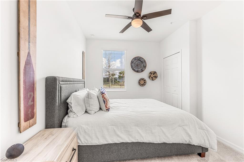 43333 Water Bird Way, Unit 4812 Babcock Ranch, FL 33982 - Photo 13 of 19 a bedroom with a bed and a chandelier