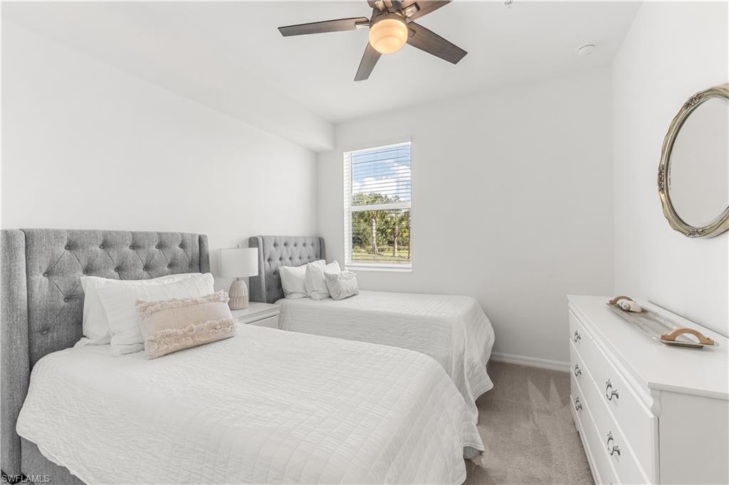 43333 Water Bird Way, Unit 4812 Babcock Ranch, FL 33982 - Photo 14 of 19 a bedroom with a bed and a chandelier