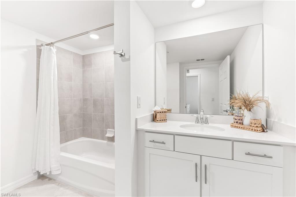 43333 Water Bird Way, Unit 4812 Babcock Ranch, FL 33982 - Photo 15 of 19 a bathroom with a tub a sink and mirror