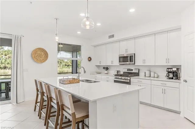 a kitchen with a dining table chairs and white cabinets