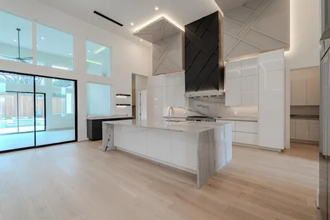a living room with stainless steel appliances kitchen island granite countertop a stove and a sink